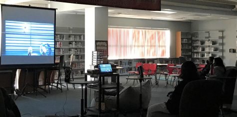 Enrichment students watch Next to normal in the library. 