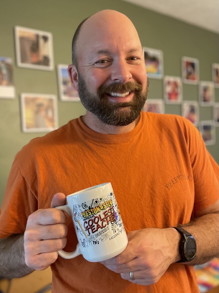 Mr. Timothy Enge posing with his "Coolest Teacher" mug from the Preston & Steve radio show.